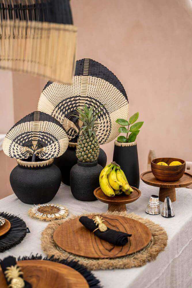 Decoratieve eettafel met De Styly Vaas in zwart en naturel, gevuld met exotisch fruit en plantaardige accenten voor kustsfeer.