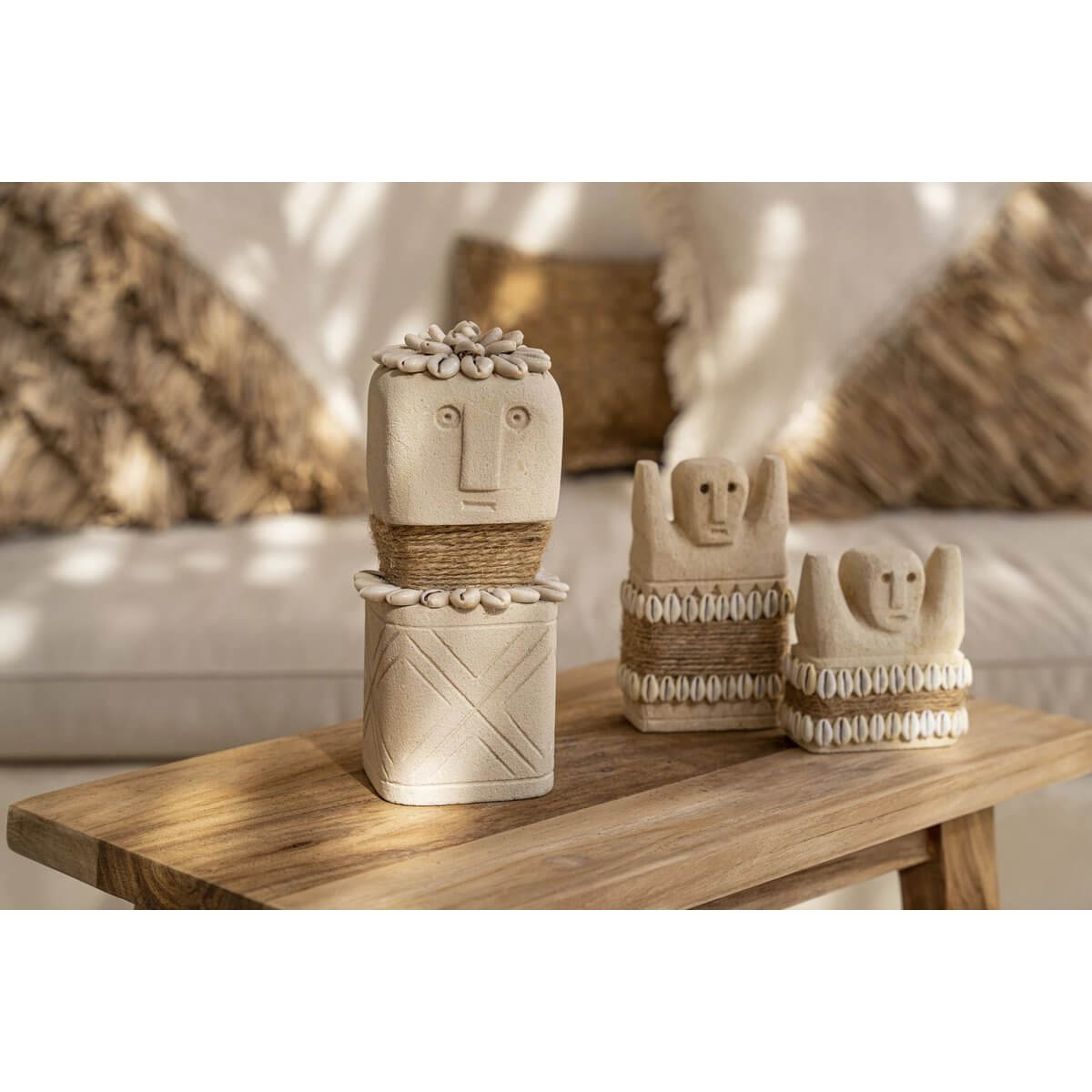 Hand-carved stone sculptures from Sumba, Indonesia on wooden table, offering a Bohemian vibe with protective cultural significance.