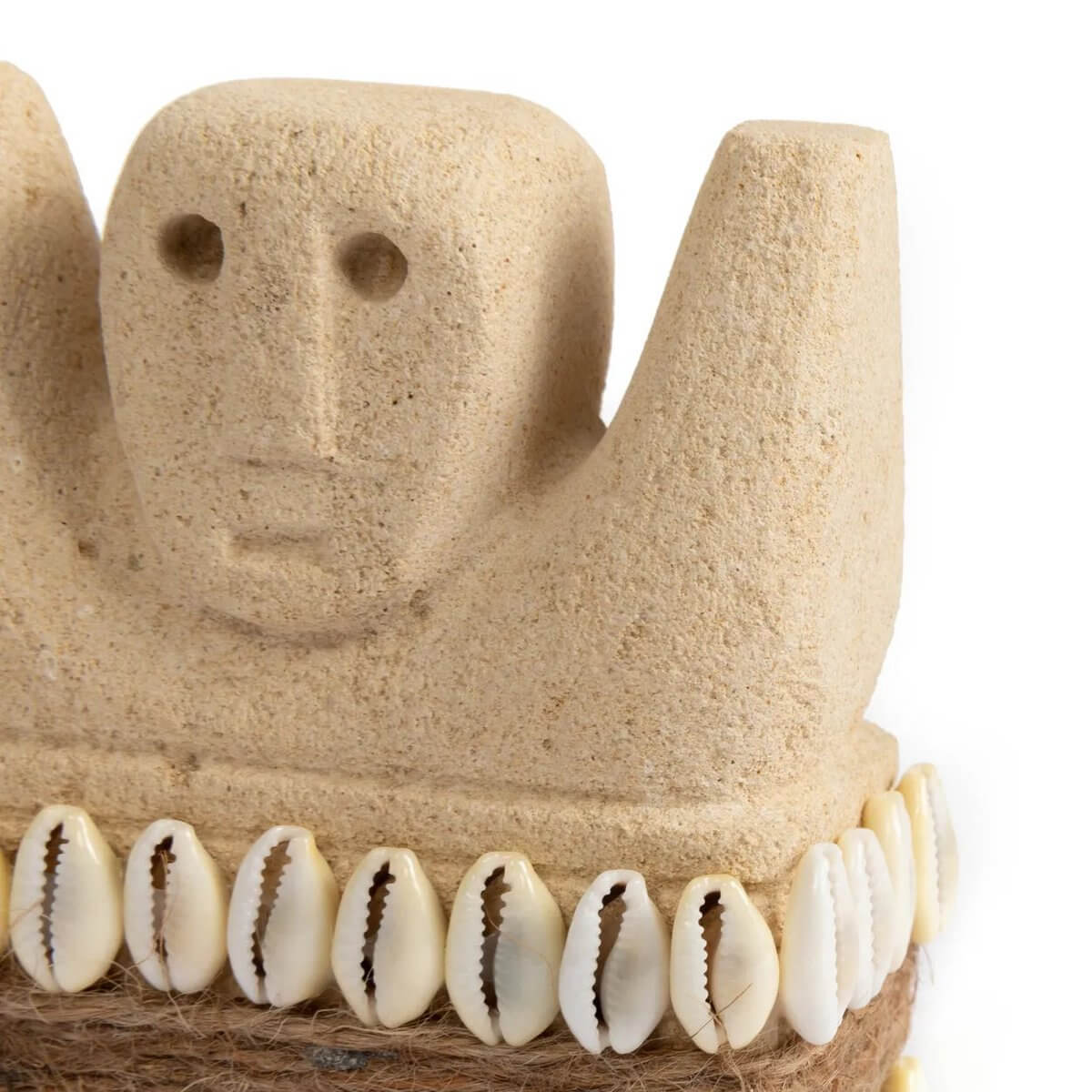 Bohemian sandstone sculpture from Sumba, Indonesia, adorned with shells, offering protection and healing in traditional villages.