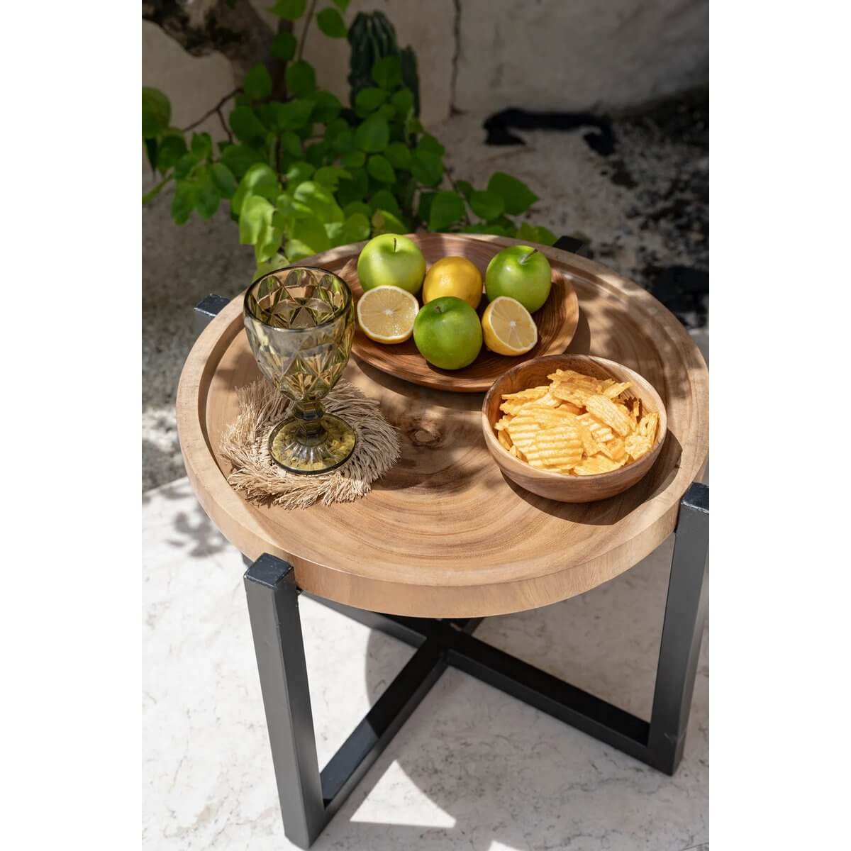 Bohemian table setting with a Teak Root Snack Bowl filled with chips, a lemon and apple bowl, and a vintage glass, on a rustic table.