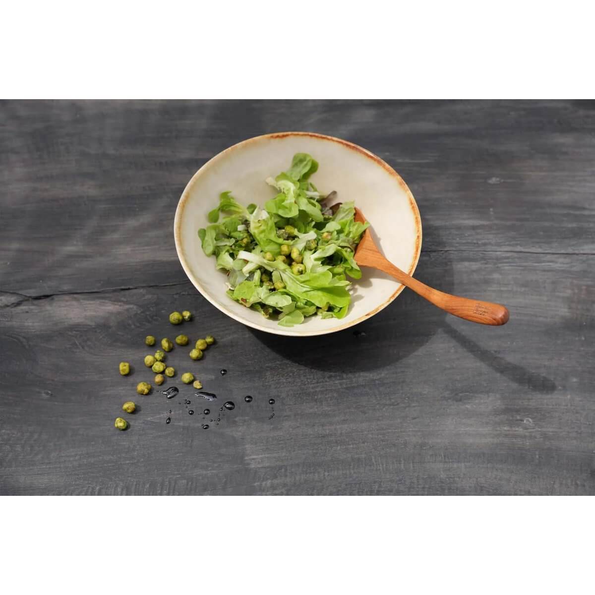 Bohemian style teakhouten wortellepel in saladekom met groene blaadjes op donkere achtergrond, van Bazar Bizar Living.