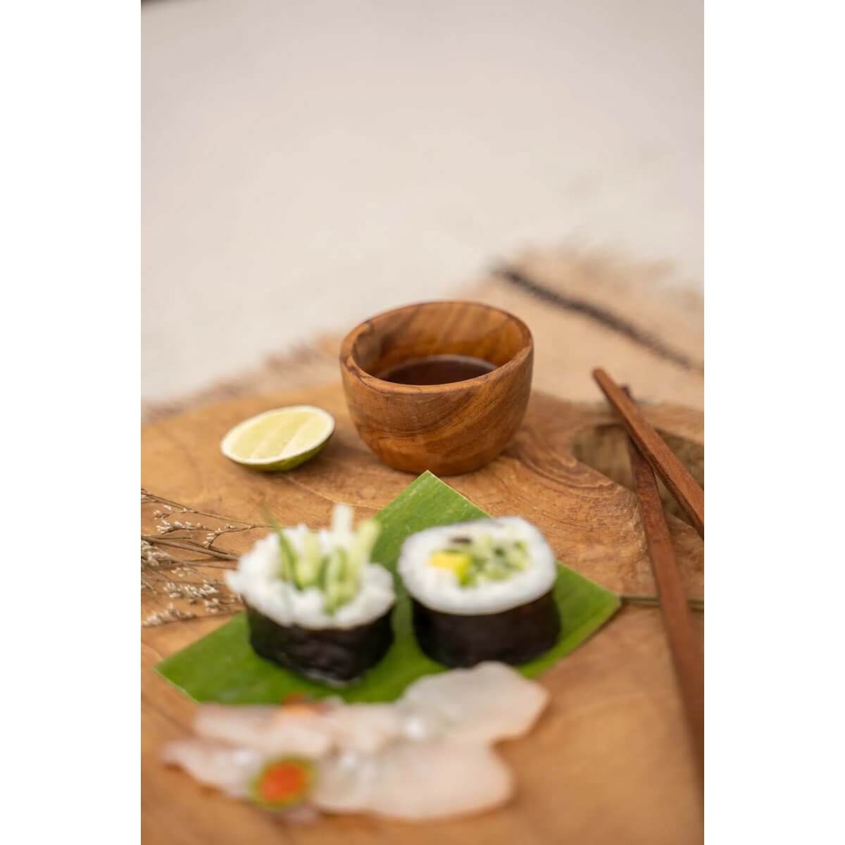 Bohemian-style Teakwortelzoutbeker XS with sushi, lime, and chopsticks on a rustic table setting.