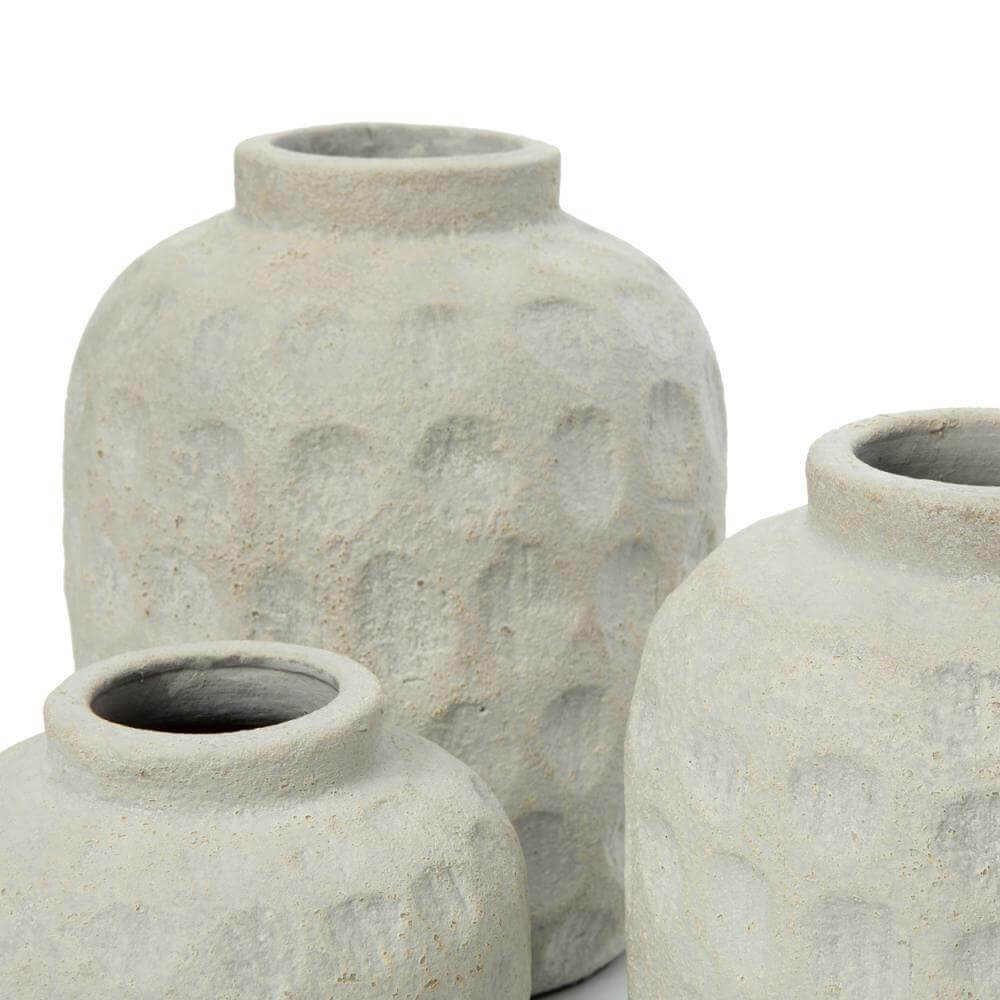 Drie terracotta vazen met eigentijds patroon in betonlook voor droge bloemen, perfect als blikvangers in huiselijke ruimtes.