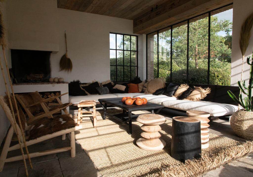 Stijlvolle woonkamer met handgemaakte De Tribe Kruk in natuurlijke en zwarte kleuren, perfect als bijzettafel of nachtkastje.