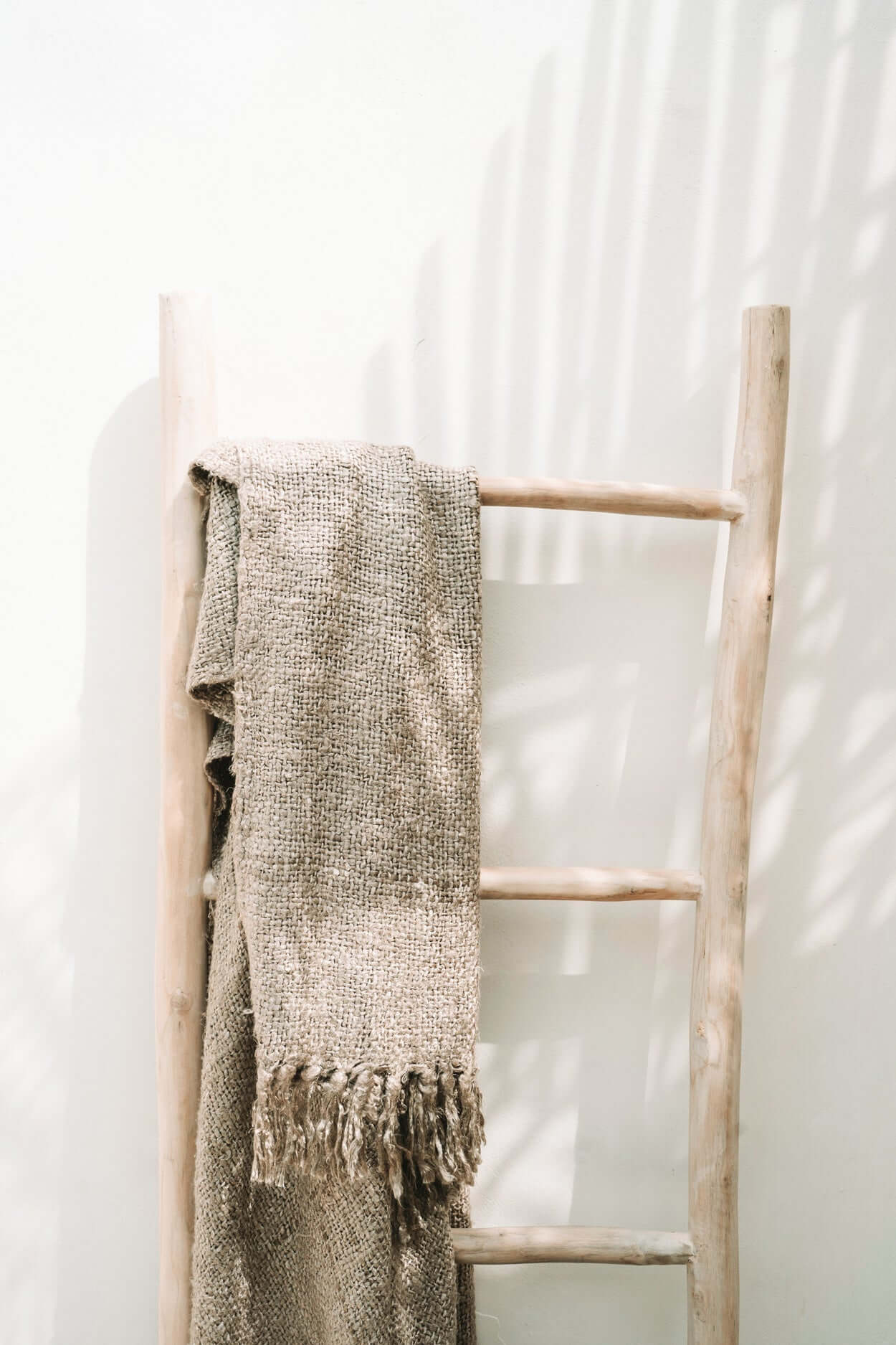 Massief teakhouten boho ladder met handdoek voor een natuurlijke look in huis of tuin. Praktische en decoratieve eyecatcher.