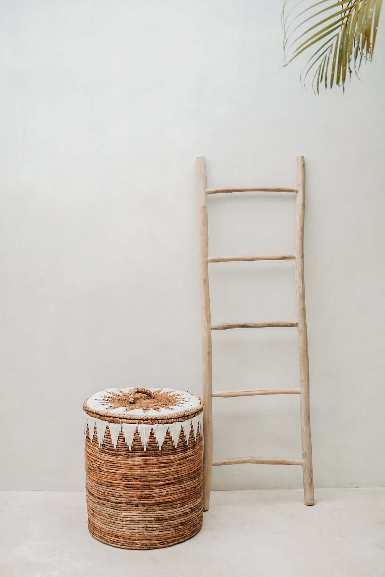 Alt Tag: Natuurlijke teak boho ladder naast decoratieve mand voor handdoeken en plaids, perfect voor badkamer of woonkamer.