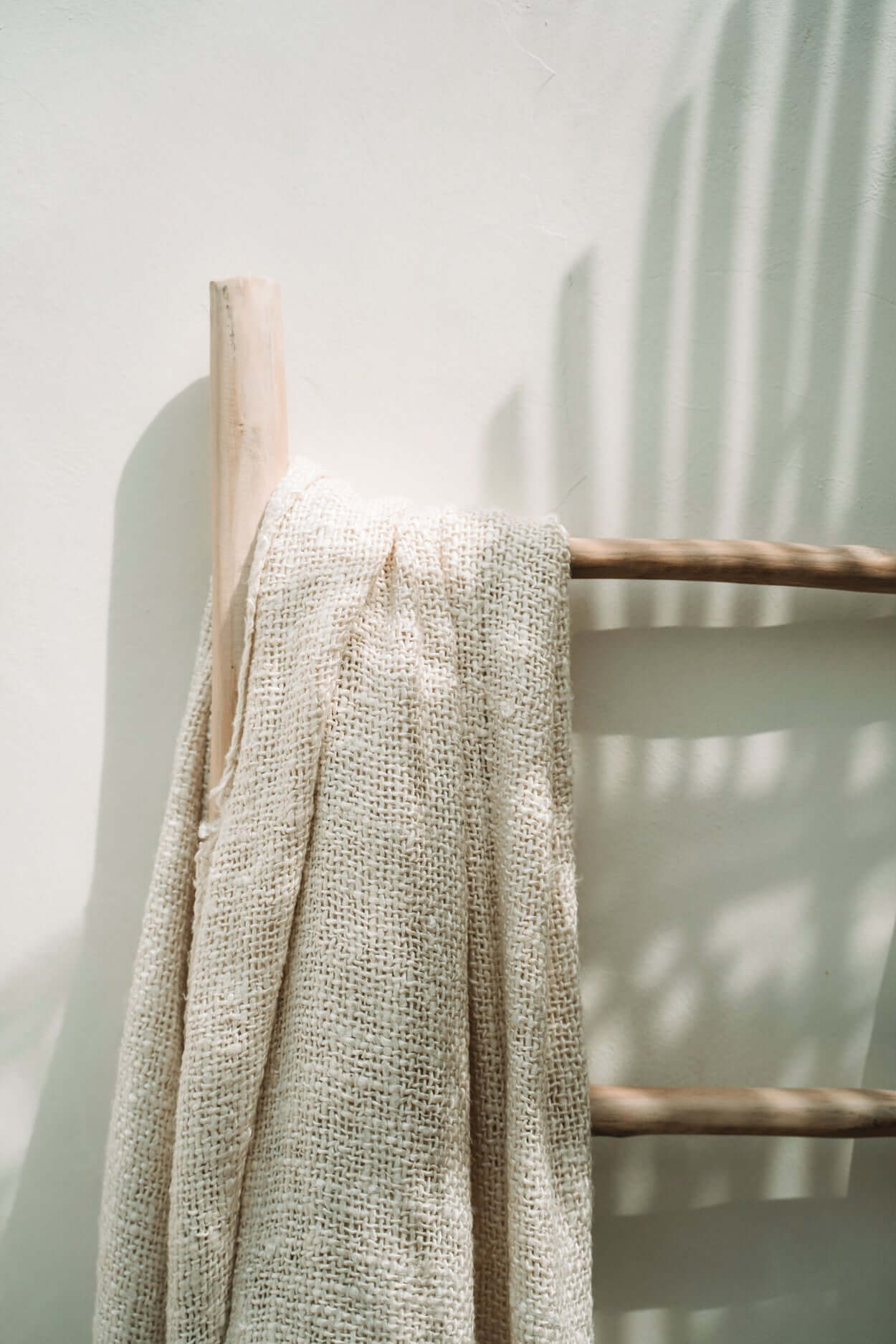 Boho de Tulum ladder van teak met decoratieve handdoek in natuurlijk licht, perfect voor badkamer of woonkamerinterieur.