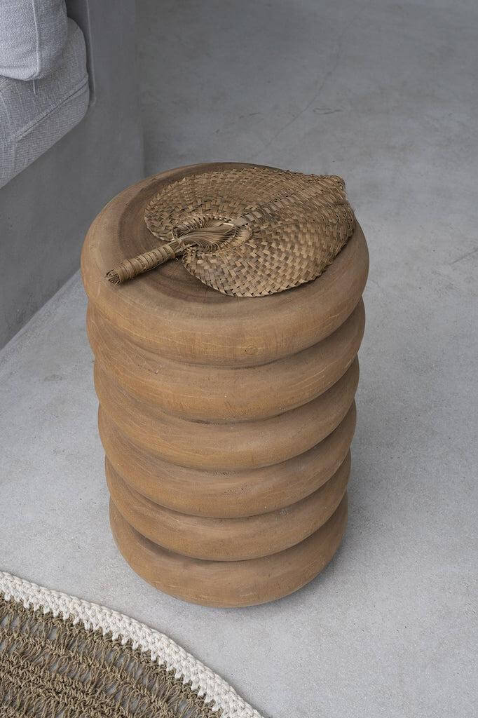 Houten kruk of bijzettafel met zes gewelfde ringen en natuurlijke afwerking, stijlvol in een moderne interieursetting.
