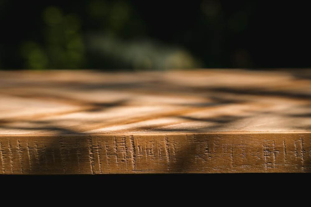 Elegant visgraatpatroon van een teakhouten console in zonlicht, perfect als tafeldecor voor binnen en buiten. Beschikbaar in naturel.