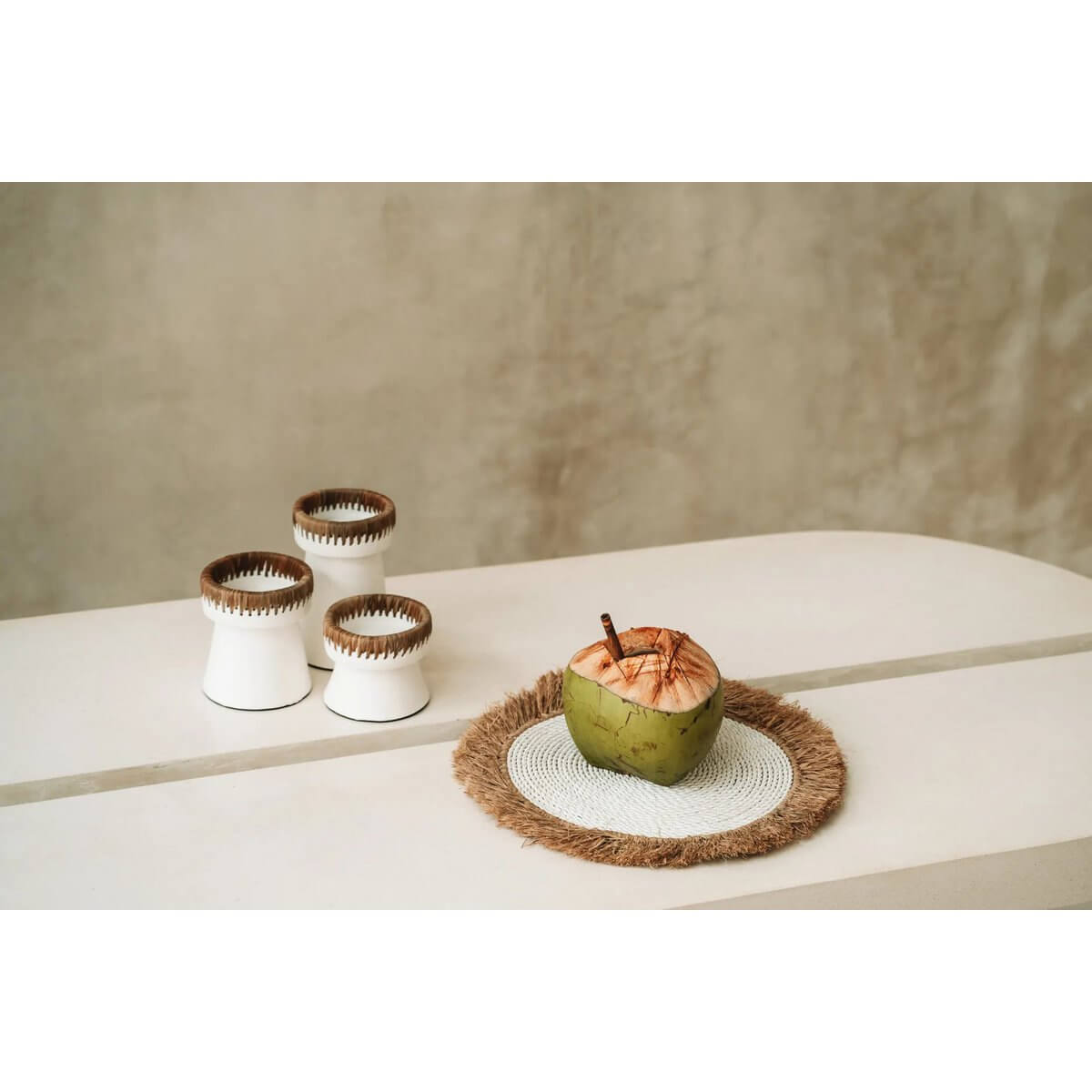 Bohemian style table setting with De Waterhyacint Raffia Placemat in white and natural tones, featuring a tropical coconut.