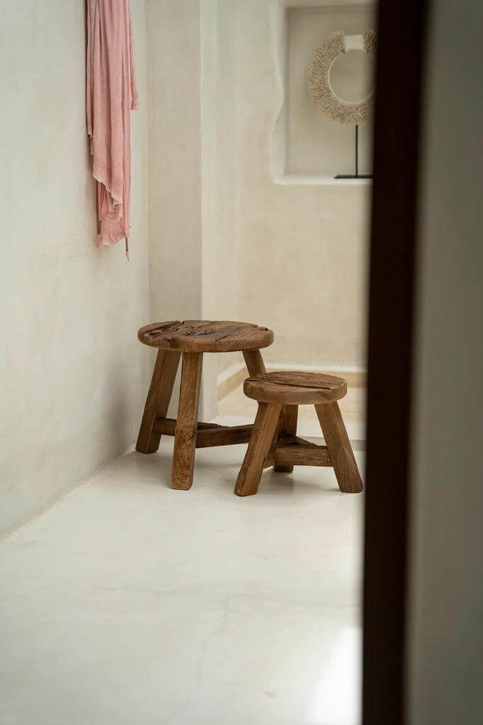 Twee Yatai krukken van gerecycled teakhout in een minimalistische kamer, ideaal als zitplaats of decoratief element met een bloempot.