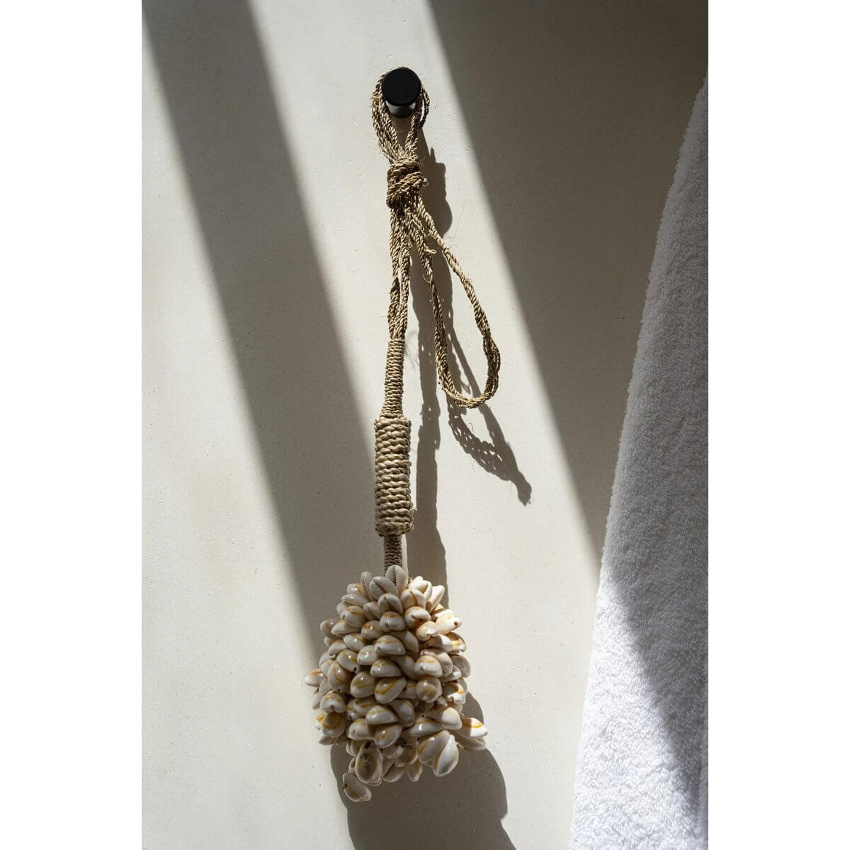 Handmade pink shell tassel by Balinese artisans, perfect for bohemian home decor; hang on doors, curtains, or walls. Brand: Bazar Bizar.