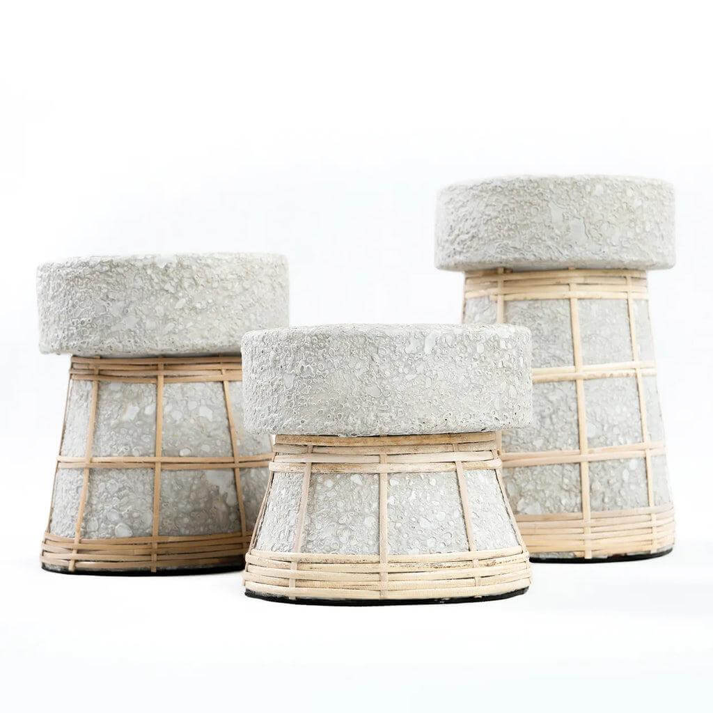 Alt Tag: Drie betongrijze terracotta kaarsenhouders met rotan details, perfect voor een gezellige sfeervolle tafel styling.