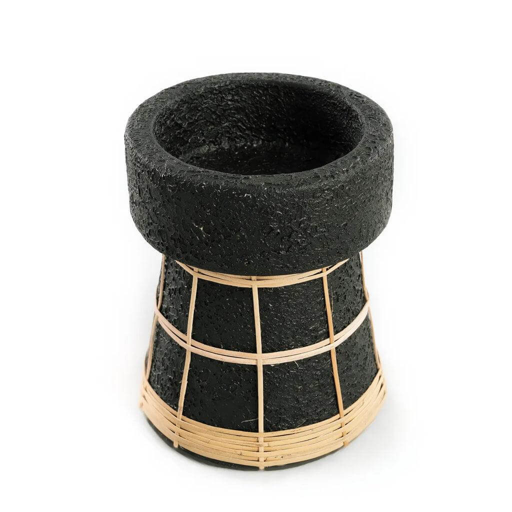 Zwarte terracotta kaarsenhouder met rotan afwerking voor gezellige tafeldecoratie.