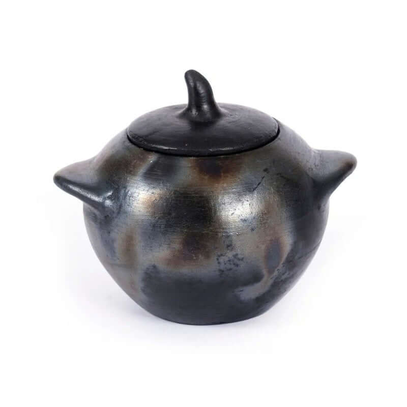 Kleine zwartgeblakerde pot met deksel uit de Burned-collectie, perfect voor suiker of zout. Contrastvolle tafelstyling met uniek servies.