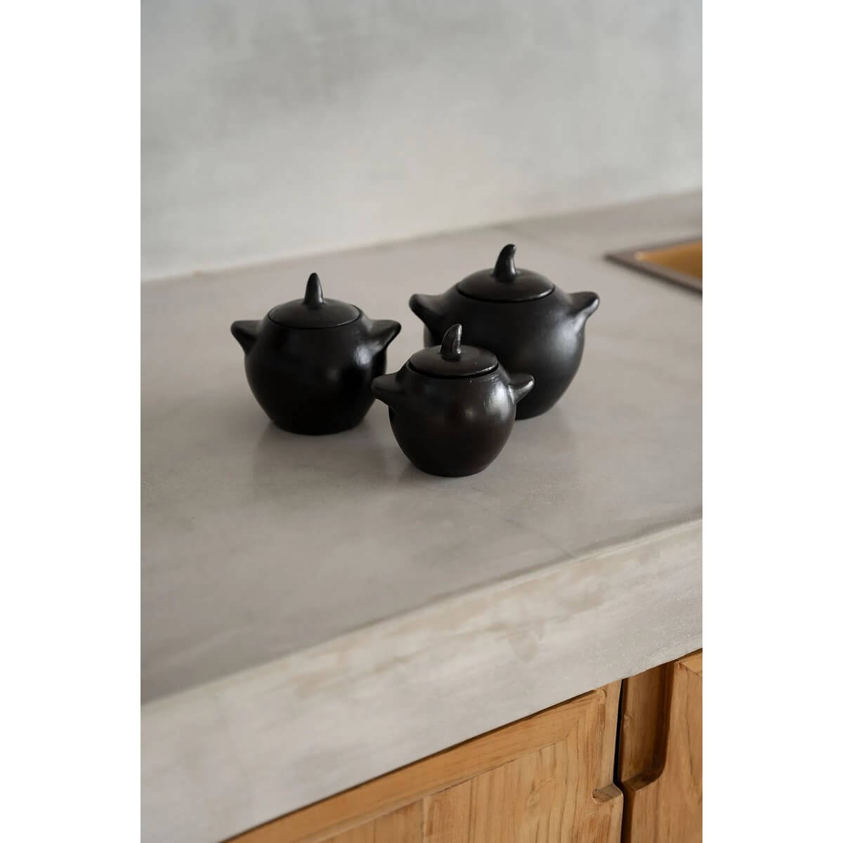 Alt Tag: Bohemian style black-burnt pots in three sizes on kitchen counter, perfect for enhancing colorful meals. Part of Burned-collection.