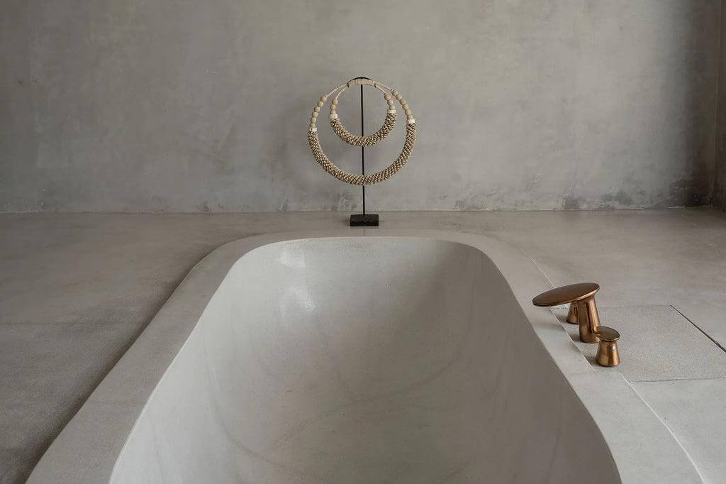 Dubbele halsketting met schelpen op standaard, versierd met houten kralen, perfect als decoratie in een stijlvolle badkamer.