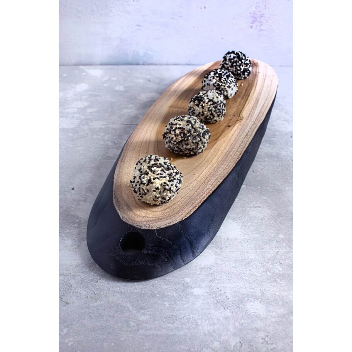 Bohemian-style teakhouten tapasbord met sesambolle snacks, perfect voor elegante gelegenheden en casual bijeenkomsten.