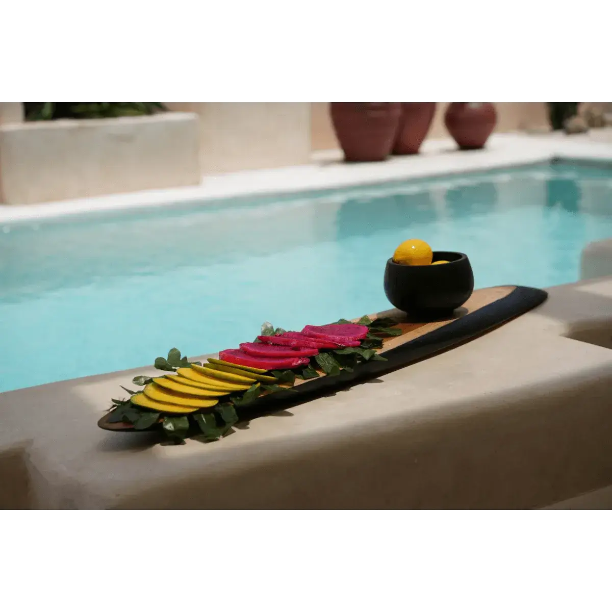 Teakhouten Bondi Tapasbord XL met kleurrijke hapjes bij een zwembad, perfect voor een Bohemian stijl brunch of diner.