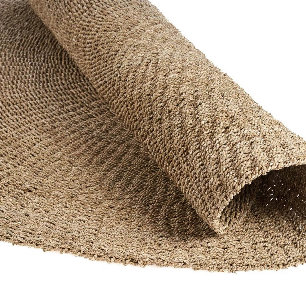 Natural sisal rug rolled out with earthy tones, perfect for adding a Bohemian touch to any room.