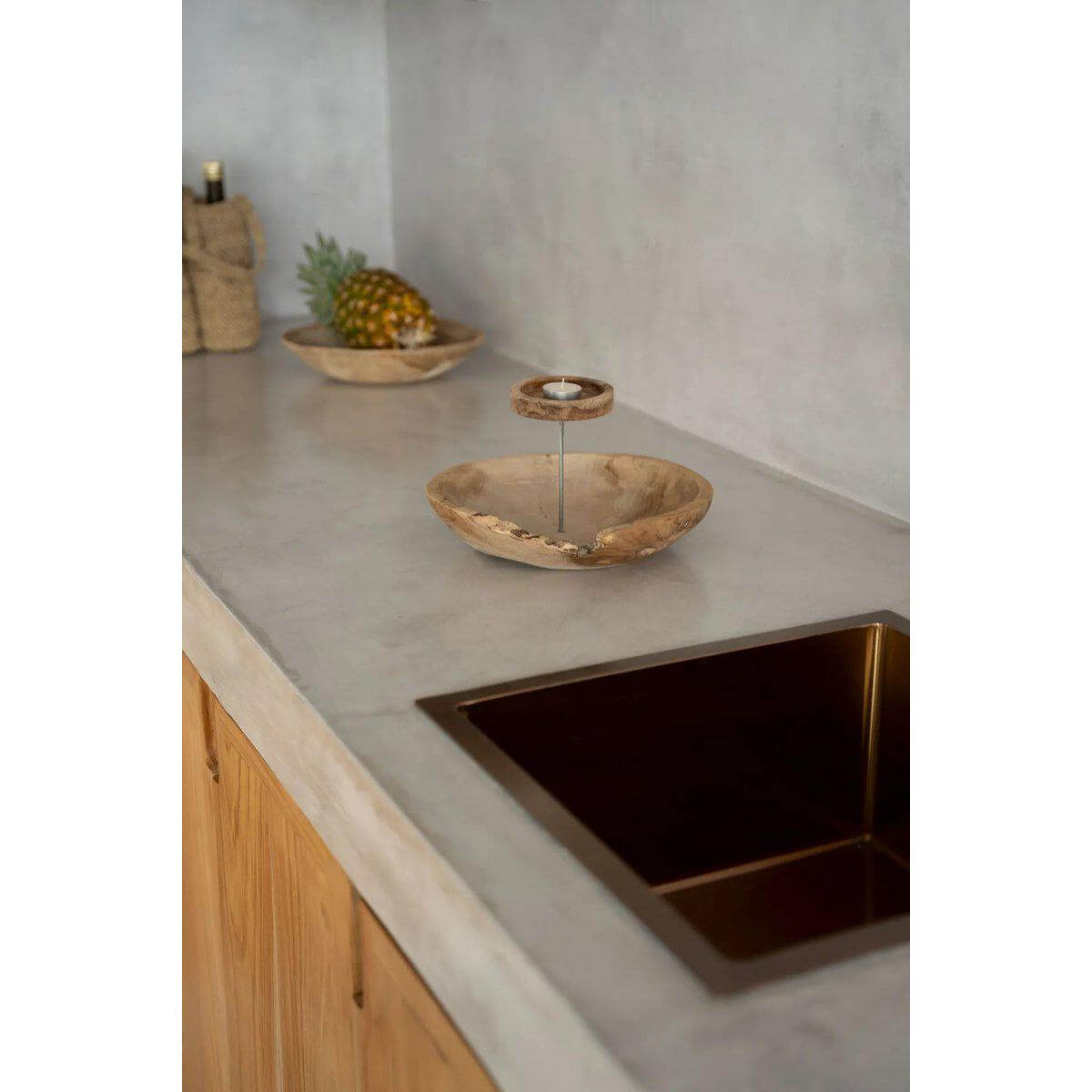 Stijlvol teakhouten kaarsenbord op een keukenblad, met fruit en een gootsteen op de achtergrond.