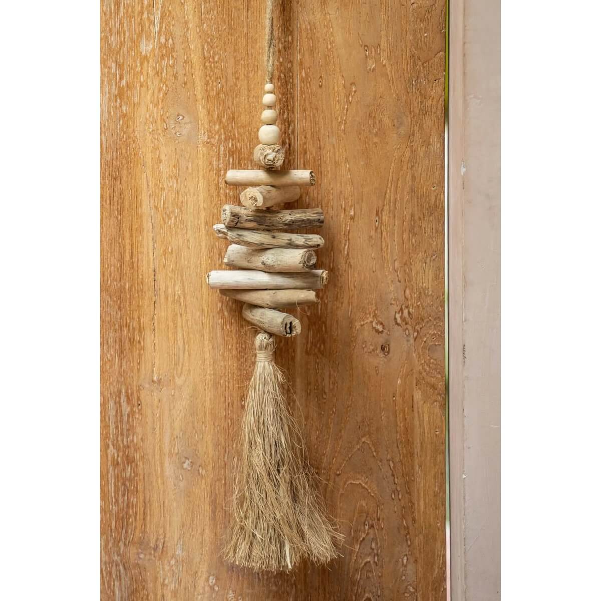 Handmade driftwood and raffia tassel by Balinese artisans, adding exotic bohemian charm to home decor. Bazar Bizar Living.