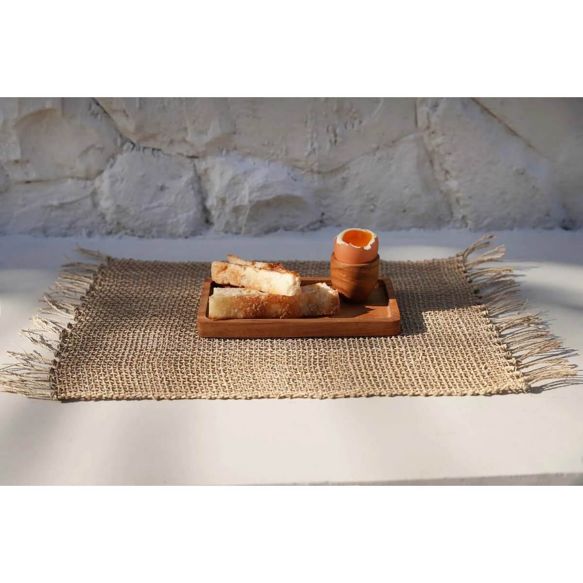 Bohemian teak root egg cup set on a rustic woven mat with toast soldiers, showcasing natural elegance and style.