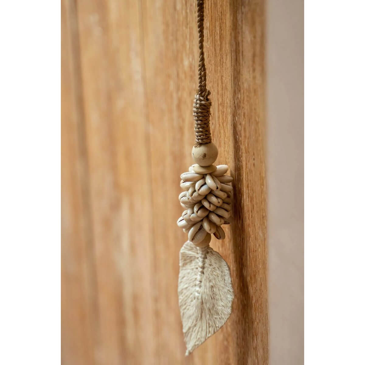Handmade Bohemian shell tassel for home decor with natural leaf design by Balinese artisans. Perfect for doors, curtains, or walls.