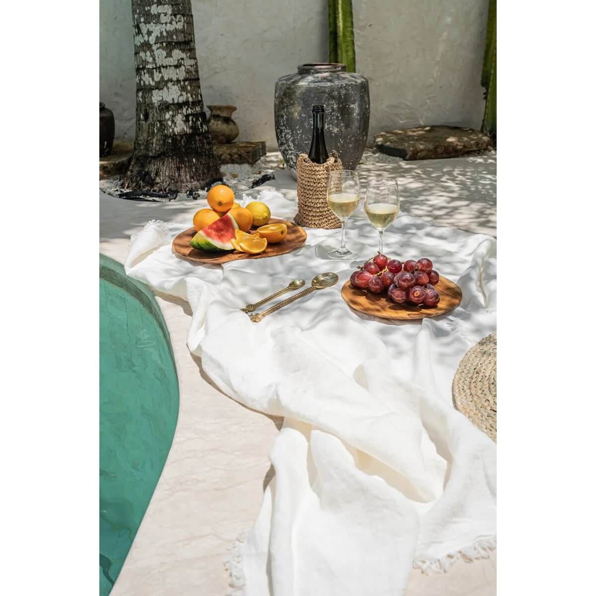 Luxe wit linnen tafelkleed 150x150 met fruit en wijn op tafel bij het zwembad, ideale outdoor tafelsetting.