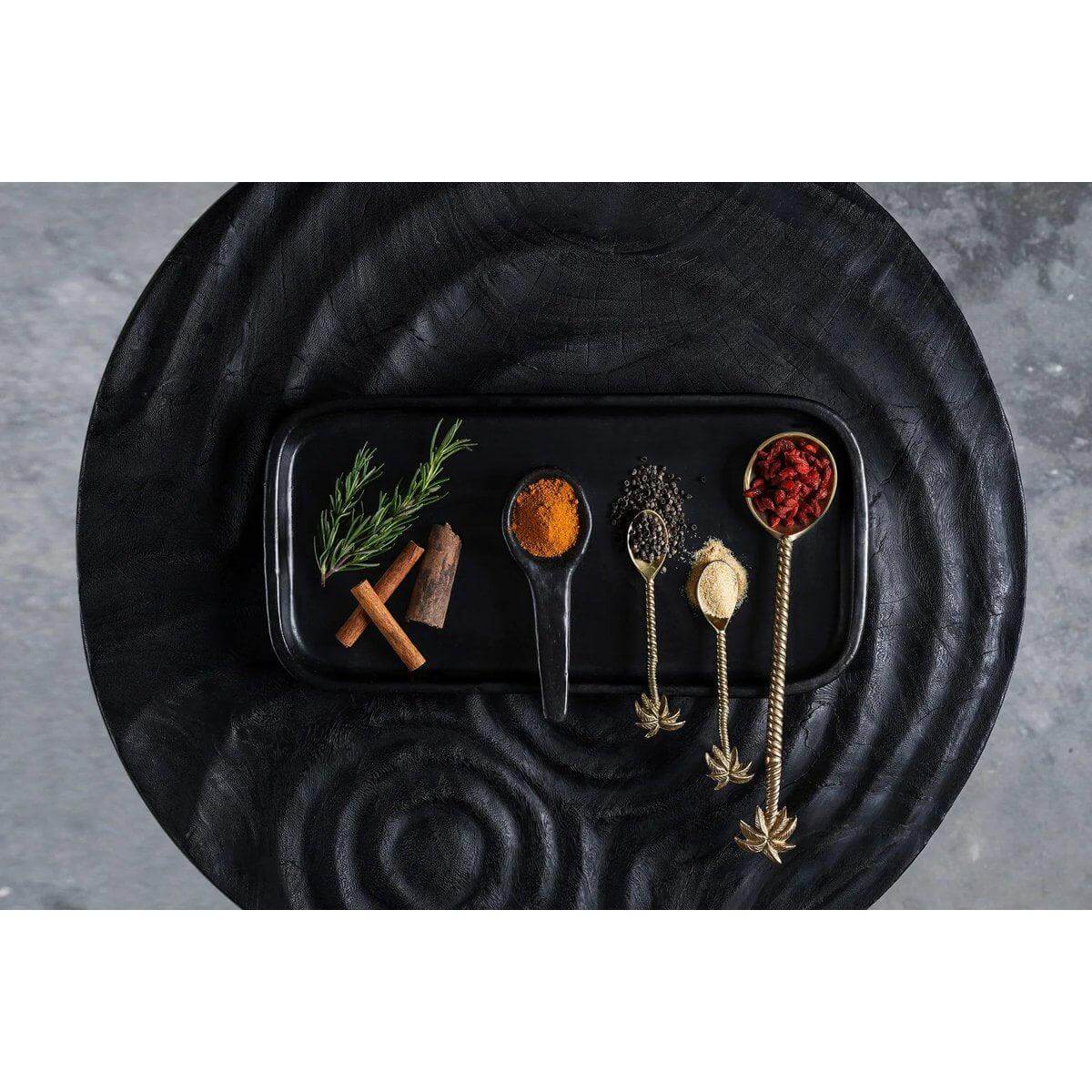 Zwart terracotta tapasbord met kruiden en specerijen, perfecte presentatie voor delen en genieten.