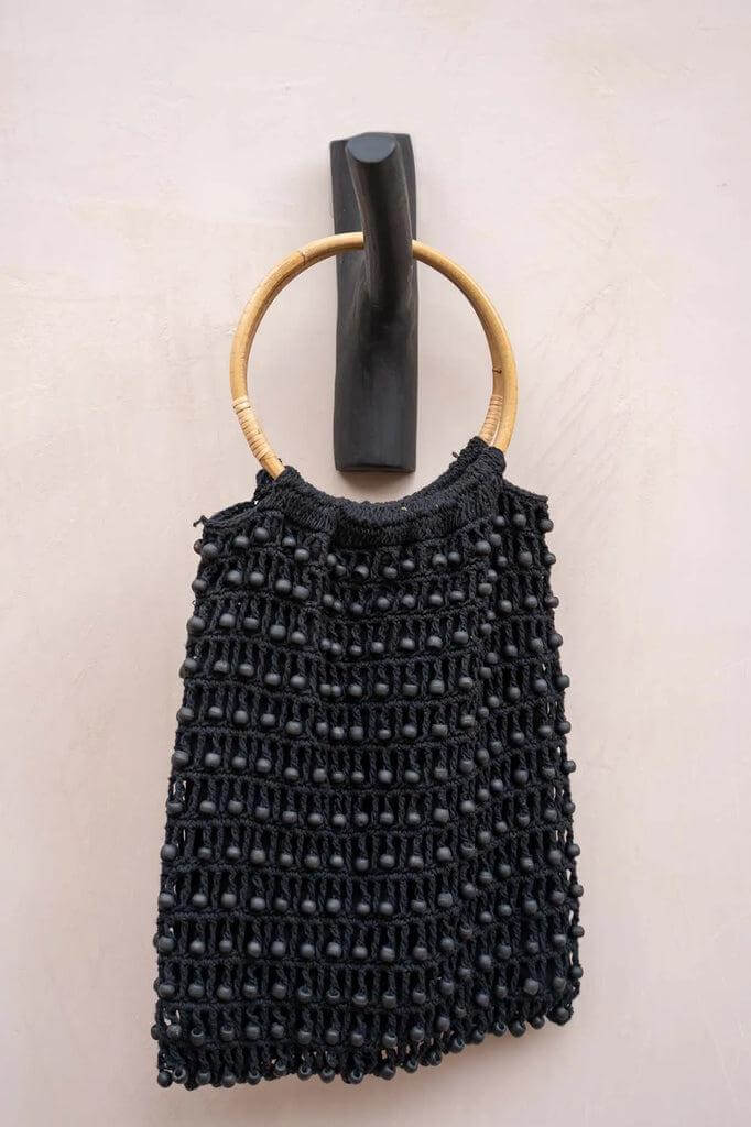 Alt Tag: Houten kapstok The Hook Zwart met stijlvolle handtas op strand interieur muur vastgemaakt.