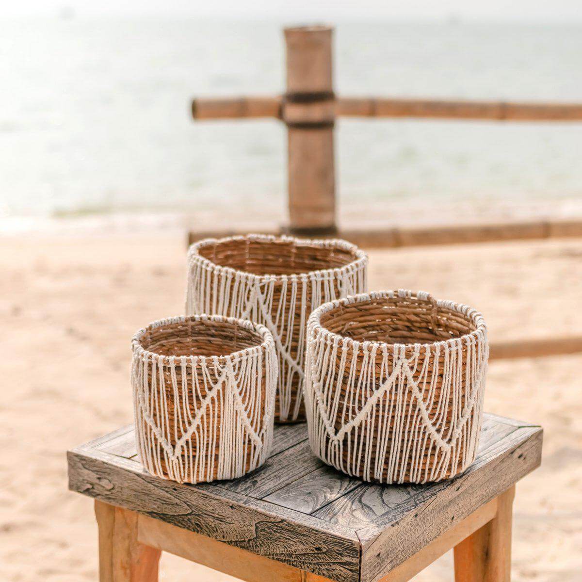 Set van drie zeegrasmanden ORIS op houten tafel bij het strand, handgemaakt met katoenen koorden, ideaal voor planten of opslag.