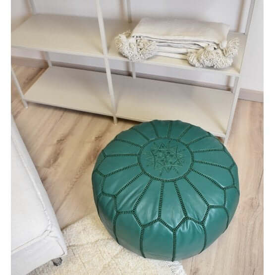 Groene Marokkaanse leren poef in woonkamer setting, perfect voor een boho sfeer als decoratie, voetenbankje of extra zitplaats.