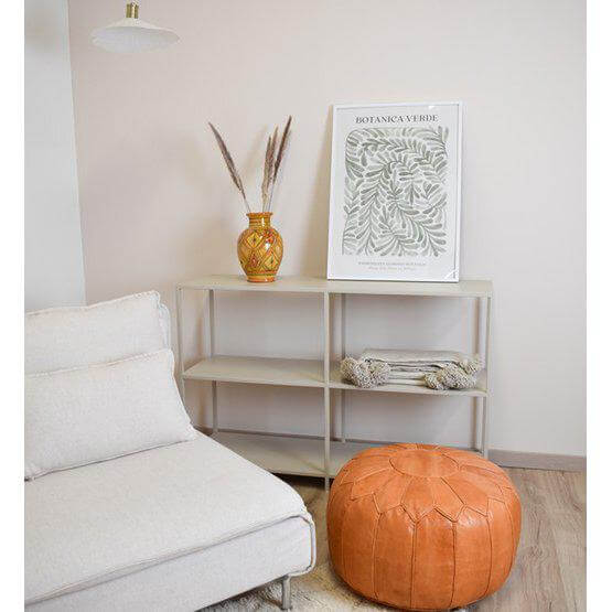 Zandbruine Marokkaanse leren poef XL in een boho woonkamer met lichte bank en decoratieve elementen.