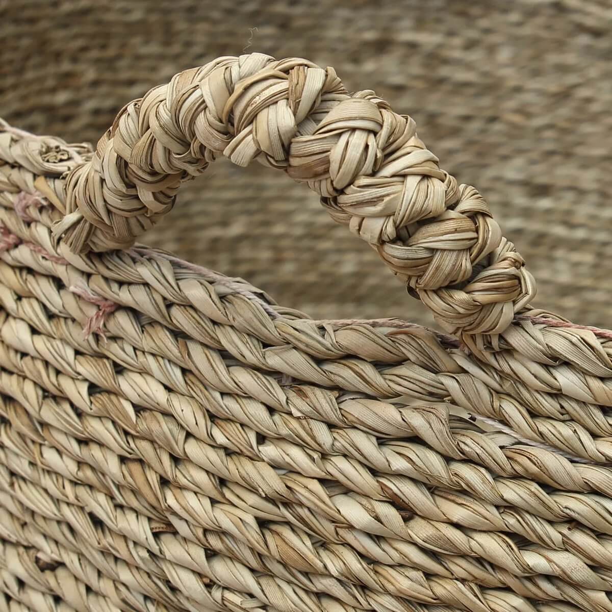 Zeegras geweven Quatre Mains Basket met vier handvatten, perfect voor wasgoed of speelgoedopslag, past bij modern en boho interieur.