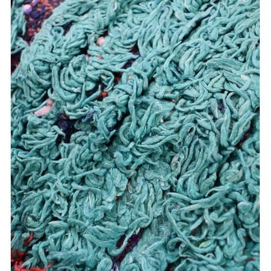Close-up van een Marokkaans Boucharouite-vloerkussen met groene, gerecyclede textielvezels, handgemaakt door ambachtslieden.
