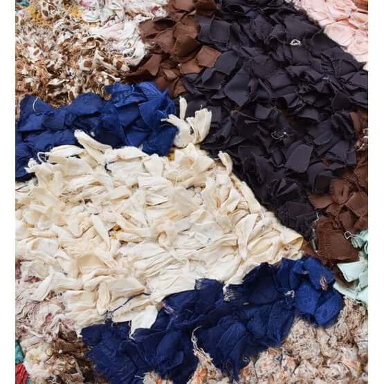 Close-up texturen van Marokkaans Boucharouite-vloerkussen met levendige kleuren en gerecycled textiel. Handgemaakt door ambachtslieden.
