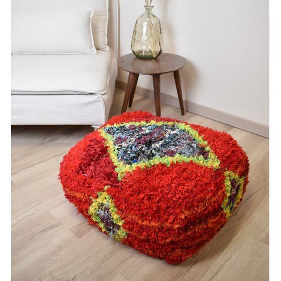 Kleurrijk Marokkaans Boucharouite vloerkussen in een woonkamer, handgemaakt van gerecycled textiel.