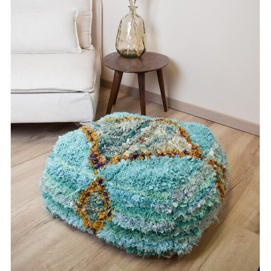 Marokkaans Boucharouite vloerkussen in levendige kleuren, handgemaakt van gerecycled textiel, voegt cultuur toe aan interieur.