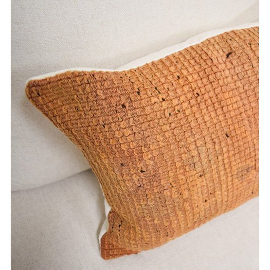 Marokkaans kussen in bohemian stijl gemaakt van vintage Berberkleed, unieke oranje textuur voor een exotische sfeer in huis.