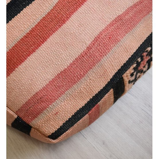 Detail van een Marokkaans vloerkussen, met roze en zwarte vintage Berber strepen en patronen, geeft een bohemian sfeer aan elke kamer.
