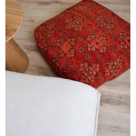 Marokkaans vloerkussen K834 met bohemian patroon, handgemaakt van vintage Berberkleed op houten vloer naast witte bank.