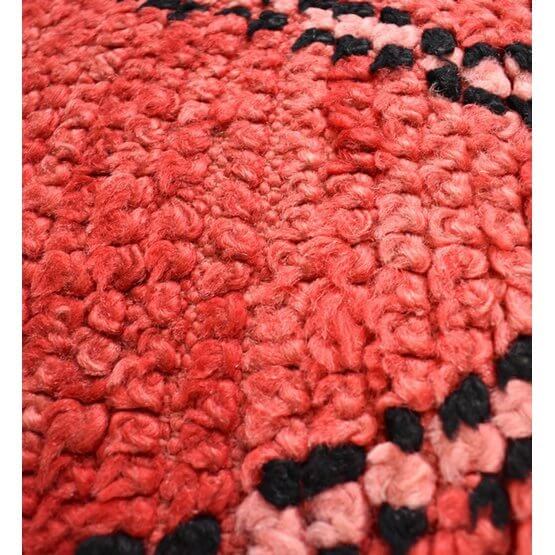 Close-up van een roze Marokkaans vloerkussen, handgemaakt van vintage berberkleden, met bohemian patroon en unieke textuur.