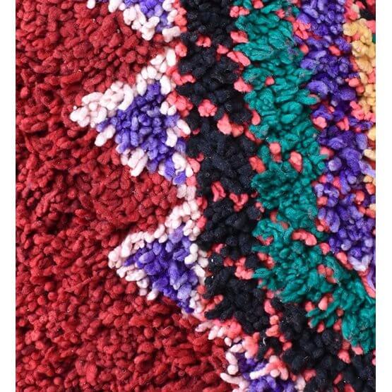 Close-up van een kleurrijk vintage Marokkaans vloerkussen, unieke Berber stijl met levendige patronen en bohemian uitstraling.