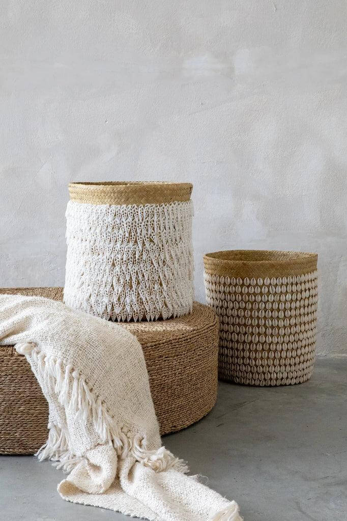 Twee handgemaakte opbergmanden van pandan met schelpenversiering, perfect voor interieurdecoratie en opbergen van wasgoed en speelgoed.