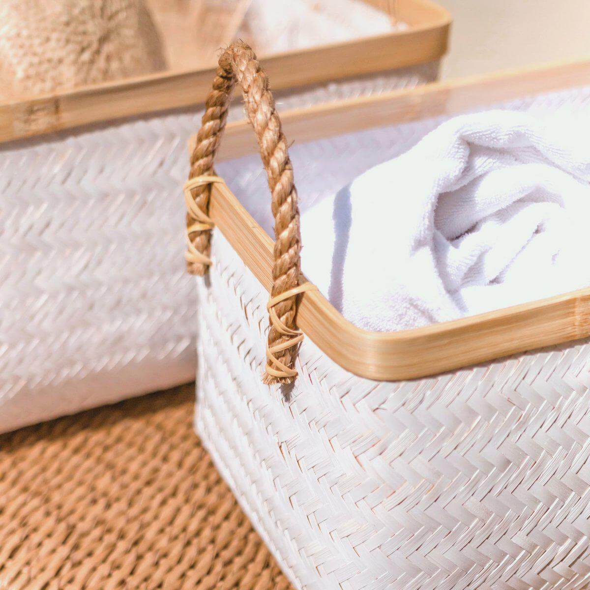 Bamboe opbergmand VAYA met geweven structuur en handvatten, handgemaakt en duurzaam, decoratieve mand op een vloerkleed.