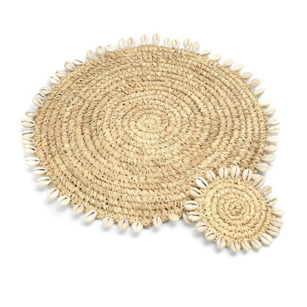 Raffia placemat met kauri schelpen omranding, perfect voor boho stijl tafelsetting.
