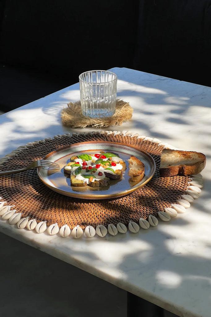 Eilandstijl placemat met kauri schelpen, handgeweven rotan. Tropisch tintje perfect voor boho interieur. Stijlvolle tafeldecoratie.