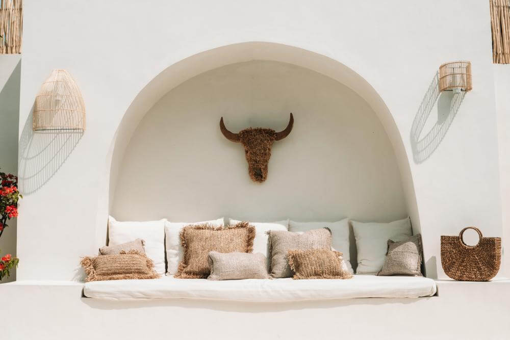 Stijlvolle bohemien zithoek met rotan wandlampen en rieten decoraties voor een gezellige sfeer.