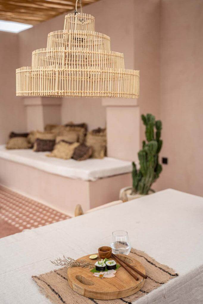 Rotan hanglamp The Wedding Cake boven eettafel, met sfeervol interieur op achtergrond. Perfect voor gezelligheid en duurzaamheid.